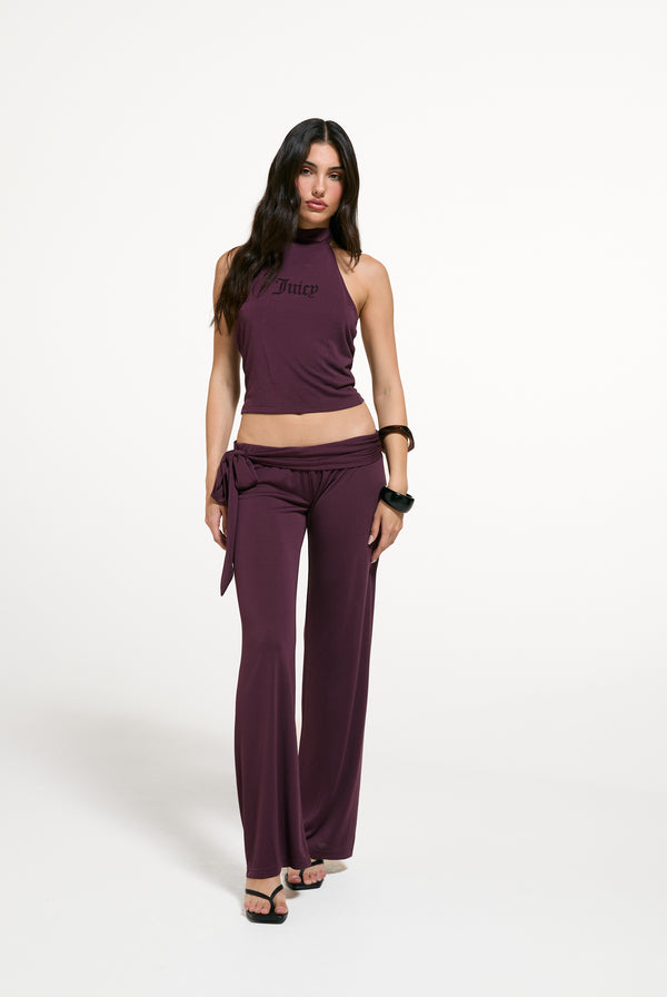 Displays a model wearing the Winetasting 'Juicy' branded Belted Flare Trousers