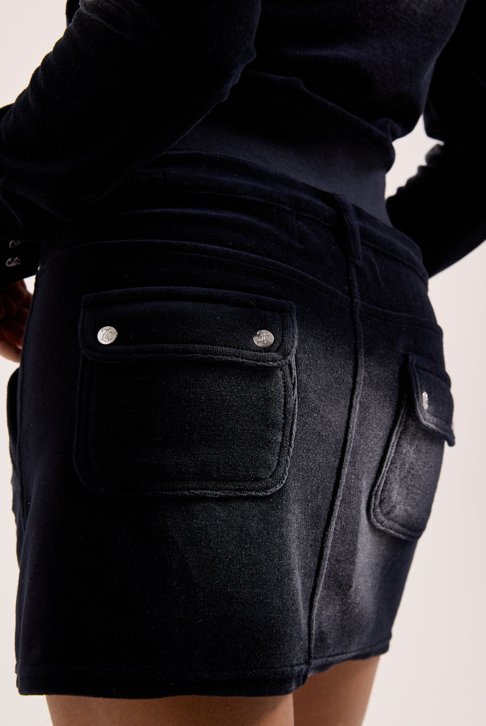 Displays a model wearing the Washed Black 'Juicy' branded Cotton velour mini skirt 