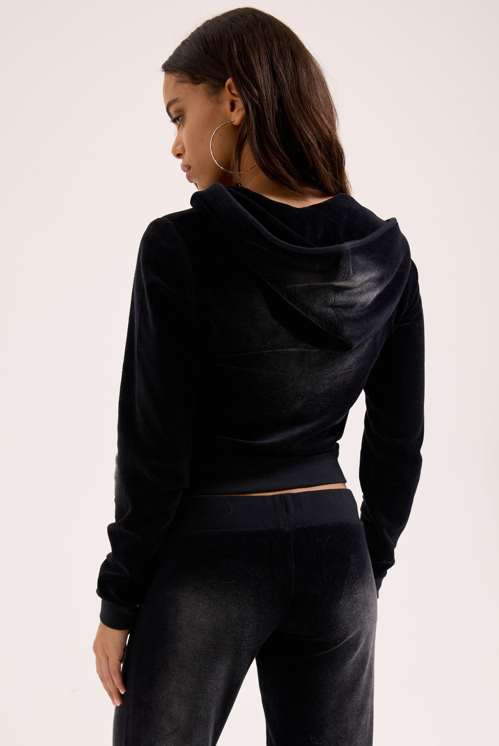 Displays a model wearing the washed black cotton 'Juicy' branded velour heritage hoodie 