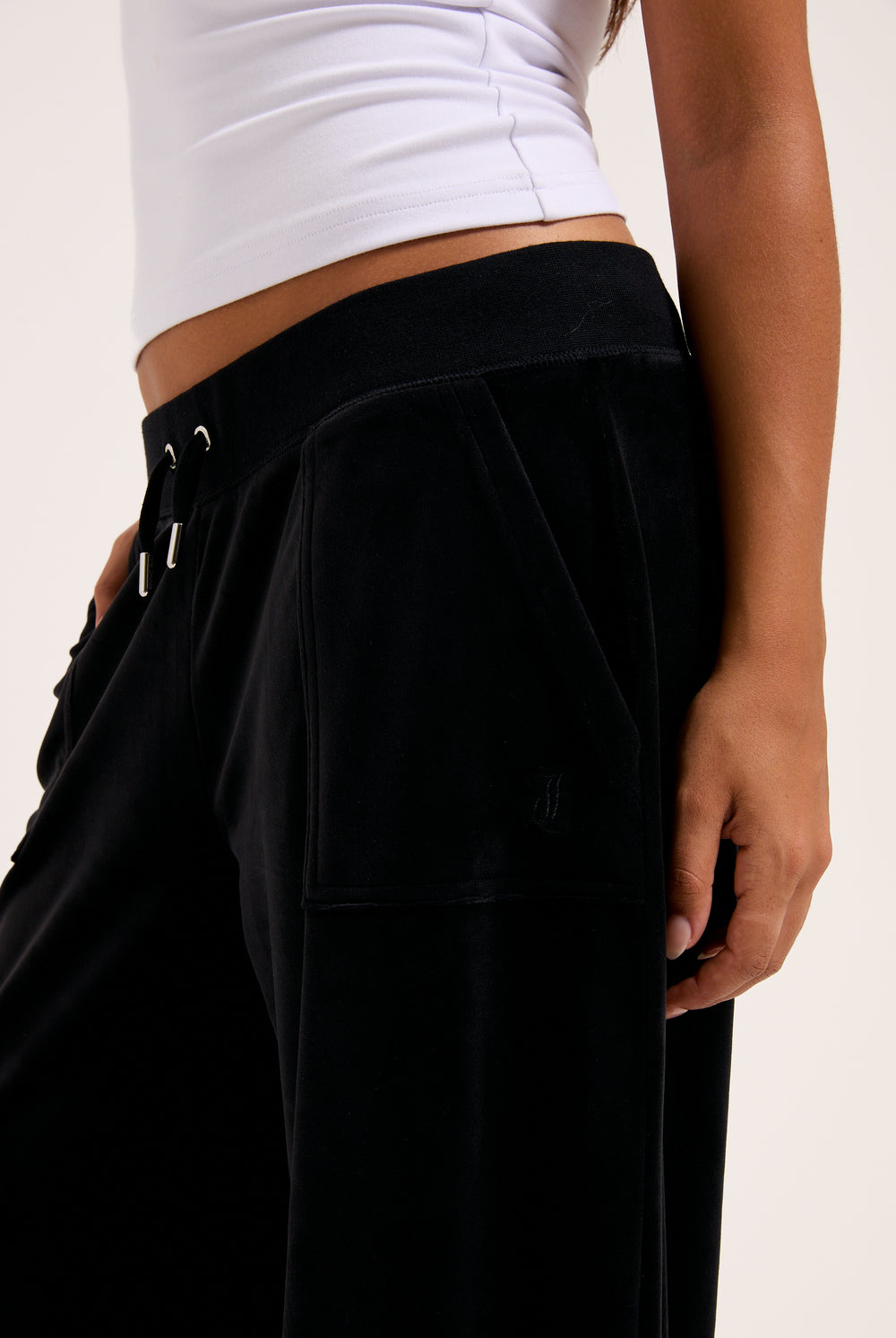 Display a model wearing the Black 'Juicy' branded wide leg classic velour track pant 