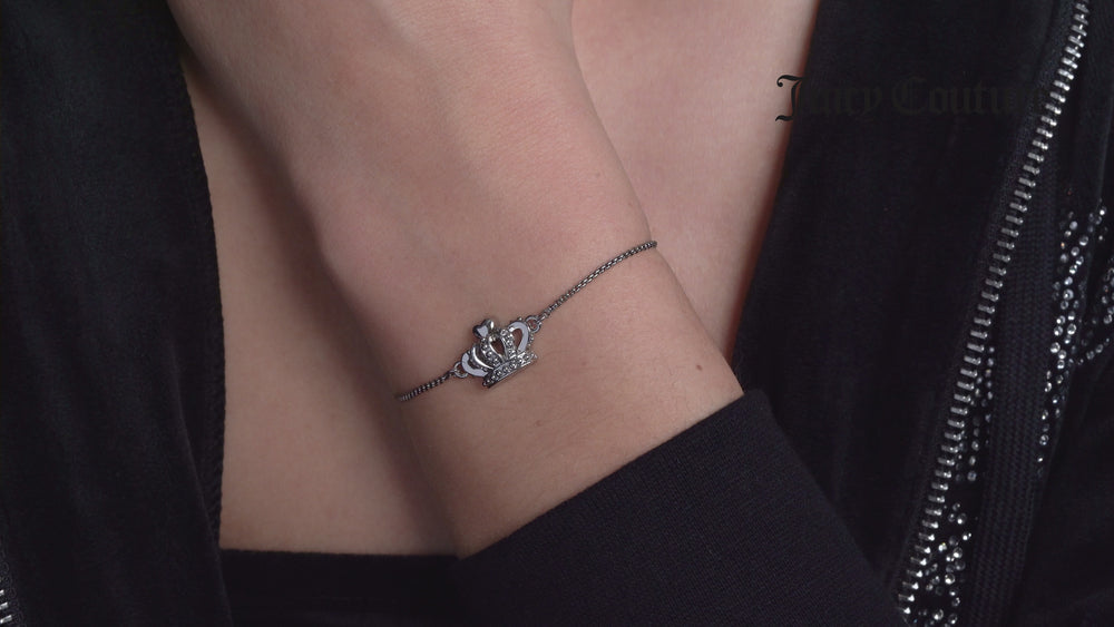 Displays a model wearing the 'Juicy' Silver Tone Icon Crown Adjustable Bracelet