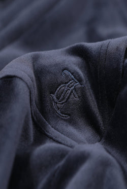 Close up of the Juicy Couture logo on a Navy Blue velour hoodie